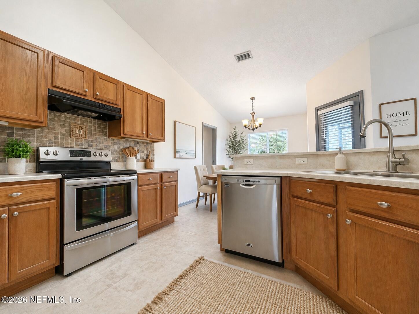 4728 Innisbrook Court North Elkton, FL 32033 - Photo 7 of 28 a kitchen with stainless steel appliances granite countertop a stove a sink and a microwave