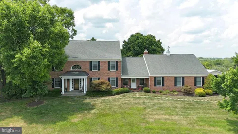 a kitchen with stainless steel appliances kitchen island granite countertop a stove a refrigerator a oven a dining table and chairs with wooden floor