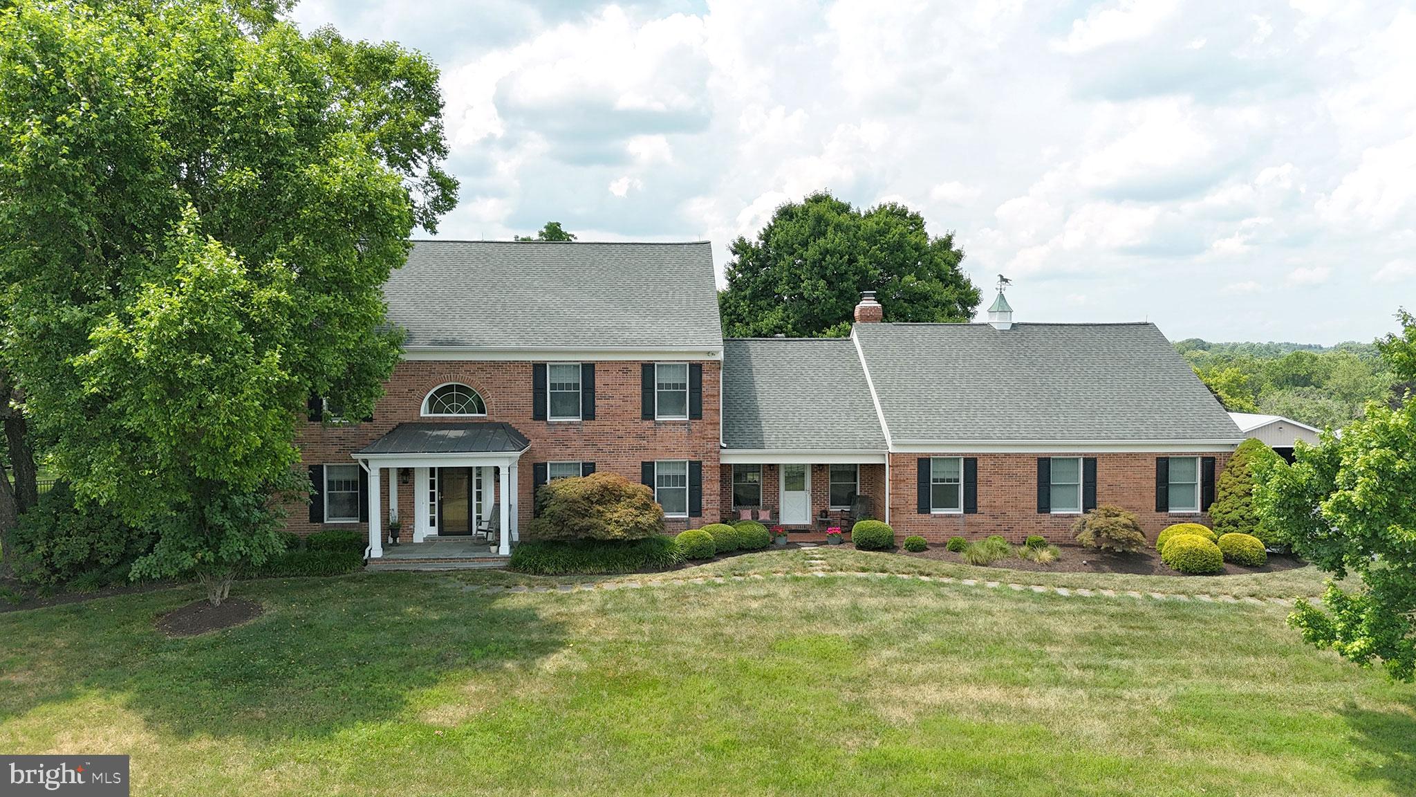 26100 Mullinix Mill Road Mount Airy, MD 21771 - Photo 7 of 99 Charming brick home with lush greenery.