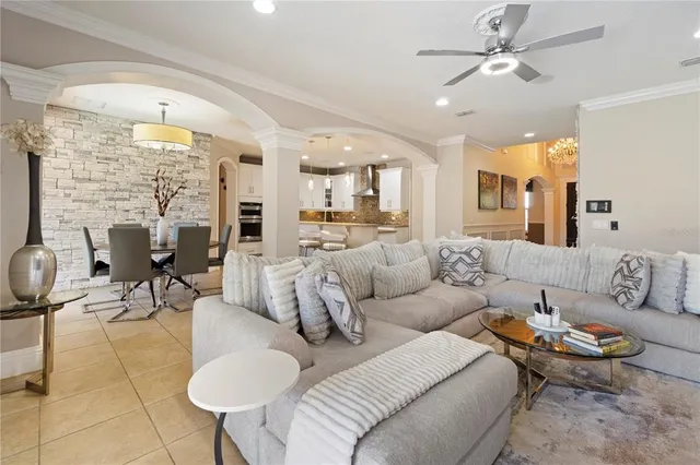 a living room with furniture kitchen view and a large window