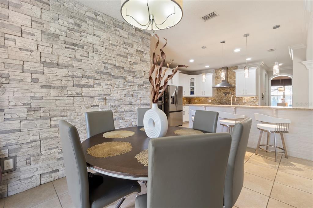 1445 Via Sangro Place Winter Park, FL 32792 - Photo 12 of 58 a dining room with furniture a rug and kitchen view