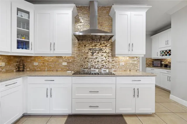 a kitchen with white cabinets and sink
