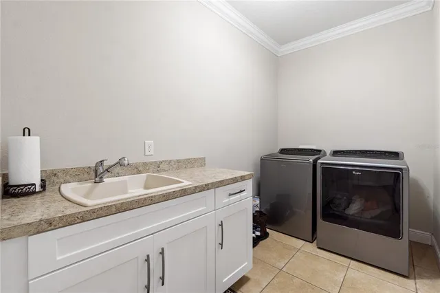 a utility room with sink dryer and washer