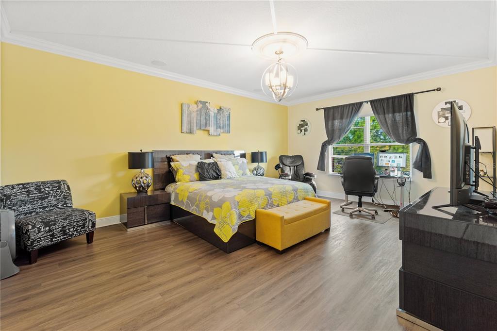 1445 Via Sangro Place Winter Park, FL 32792 - Photo 32 of 58 a spacious bedroom with a bed and a chandelier