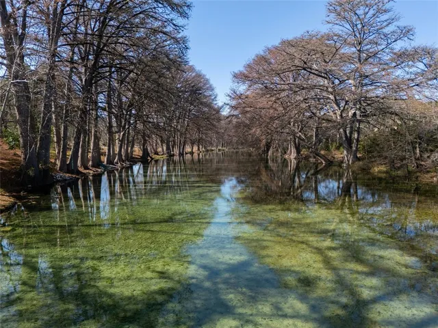 a backyard of a house with lots of green space and lake view