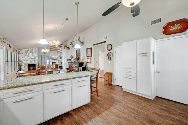 a large white kitchen with lots of counter space and wooden floor