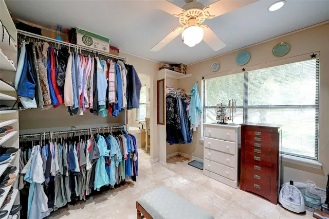 a view of walk in closet with clothes and shoes