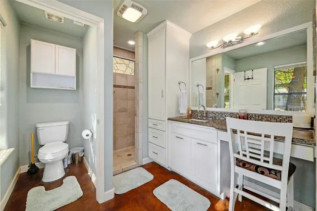a spacious bathroom with a toilet a sink and a mirror