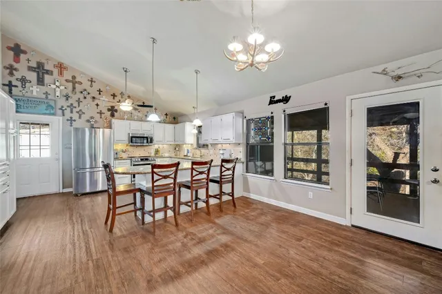 a view of a dining room with furniture and chandelier