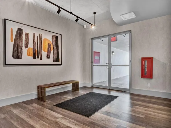 a view of a hallway with wooden floor and furniture