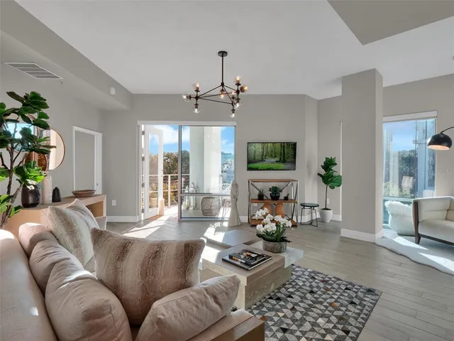 a living room with furniture a flat screen tv and kitchen view