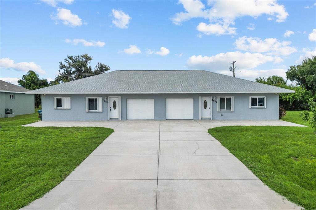 2660 Lear Road Englewood, FL 34224 - Photo 2 of 42 a front view of a house with a yard and garage
