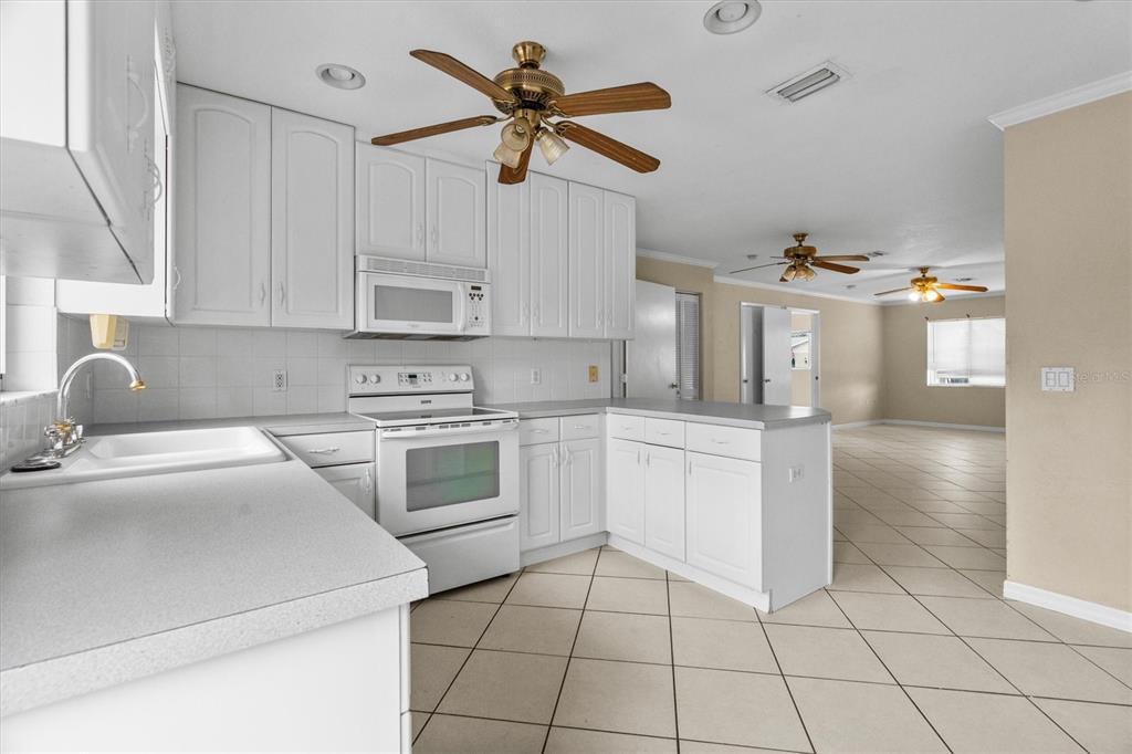 2660 Lear Road Englewood, FL 34224 - Photo 26 of 42 a kitchen with a stove a sink and a refrigerator