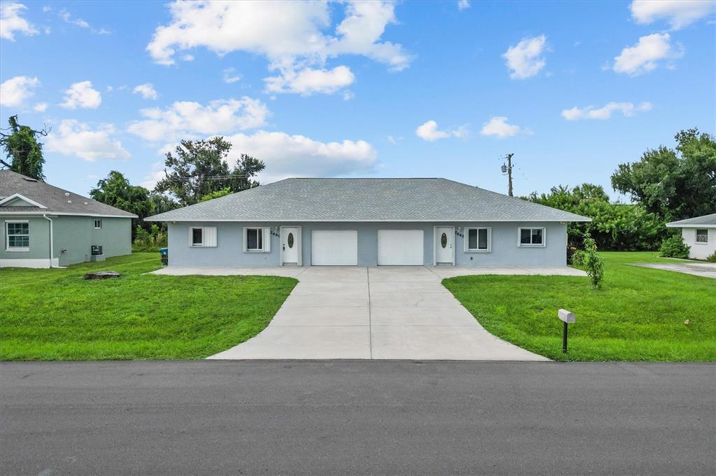 2660 Lear Road Englewood, FL 34224 - Photo 3 of 42 a front view of a house with a garden and yard