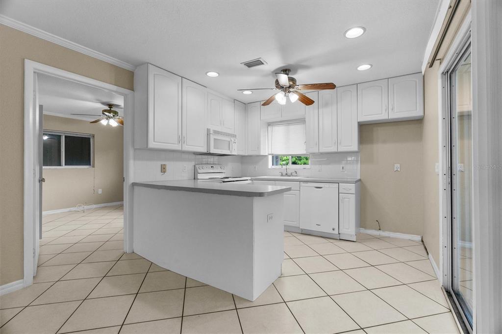 2660 Lear Road Englewood, FL 34224 - Photo 9 of 42 a kitchen with kitchen island granite countertop appliances cabinets and a sink