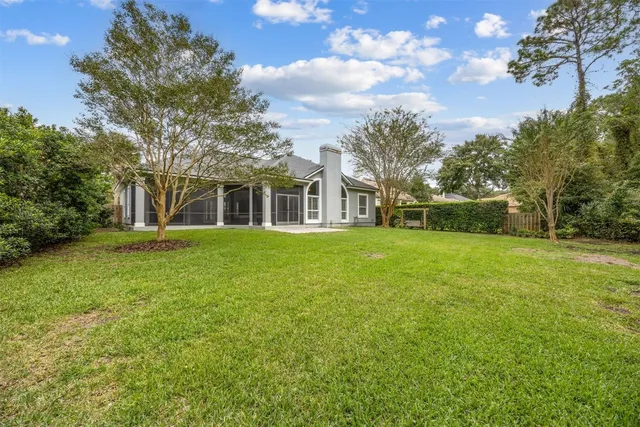 a view of a house with backyard and tree s
