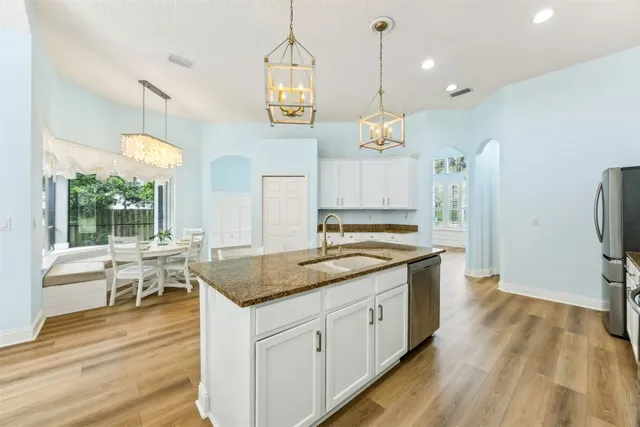 a kitchen with a sink stove and wooden floor