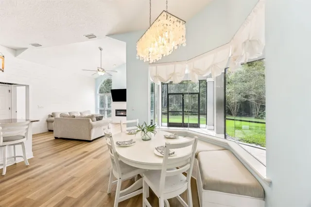 a dining room with furniture a chandelier and wooden floor