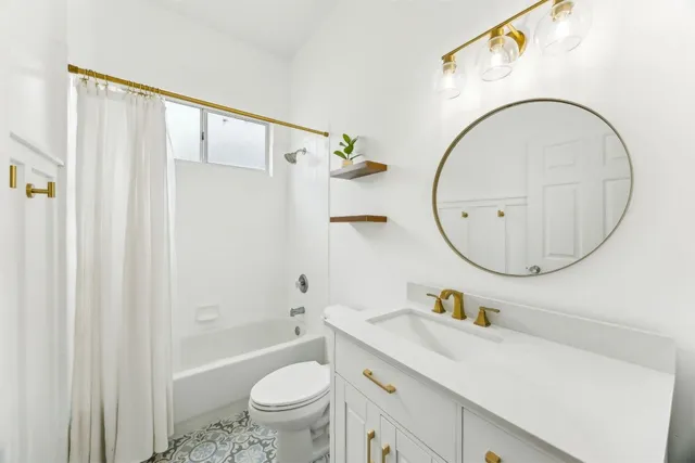 a bathroom with a sink a mirror a toilet and a shower