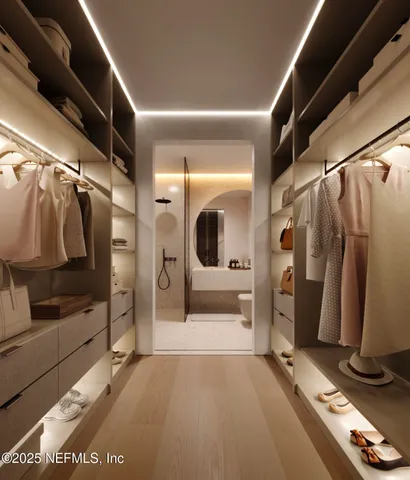 a view of walk in closet with clothes and shoes