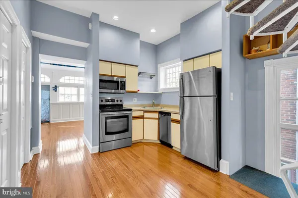 a kitchen with granite countertop a refrigerator and a stove top oven