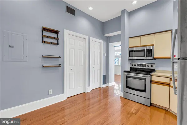 a kitchen with granite countertop a refrigerator and a stove top oven