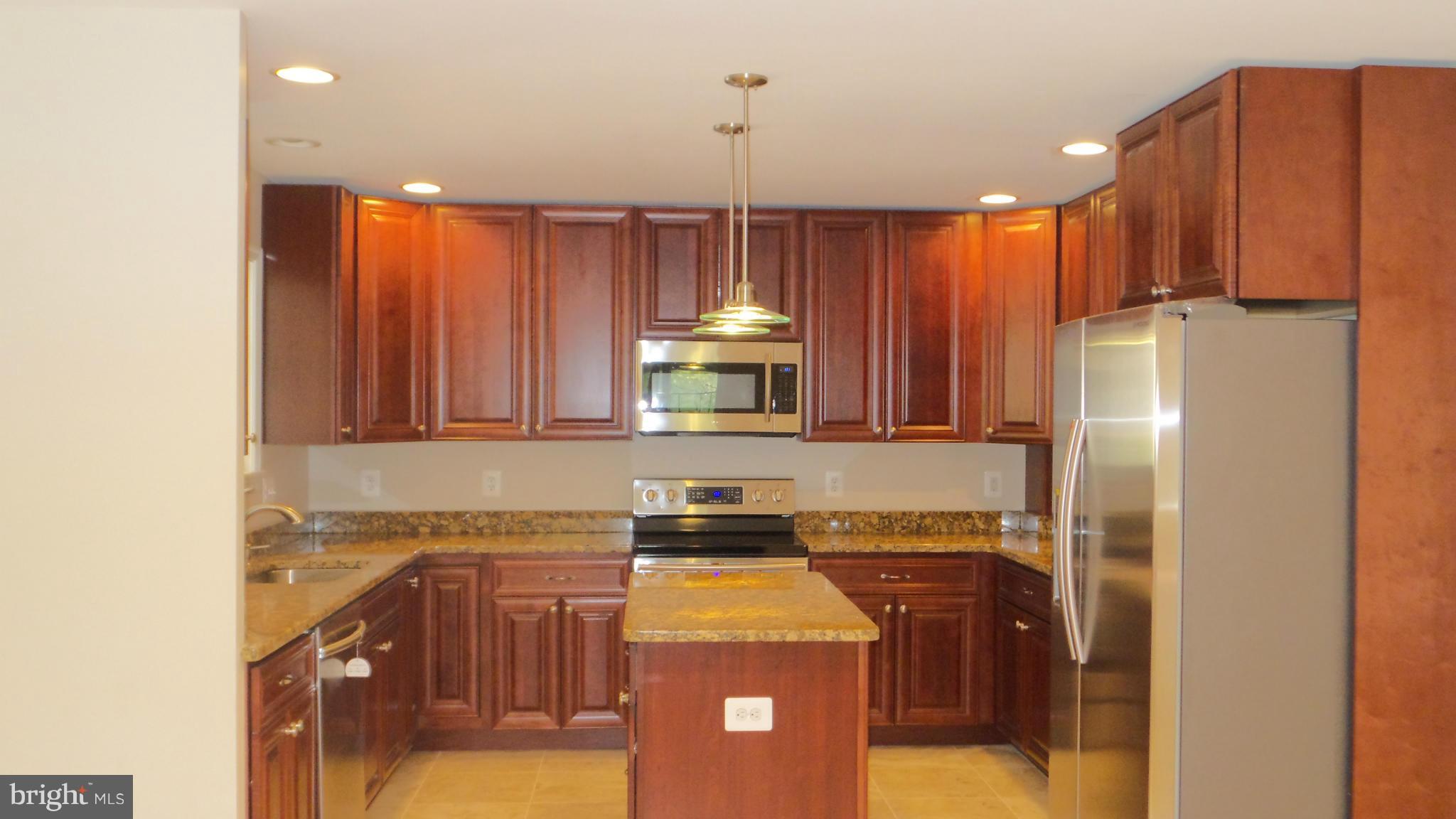13409 Bladon Road Phoenix, MD 21131 - Photo 6 of 27 a kitchen with a refrigerator a stove and a cabinets