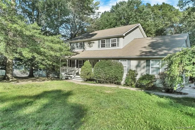a view of a house with a yard and sitting area