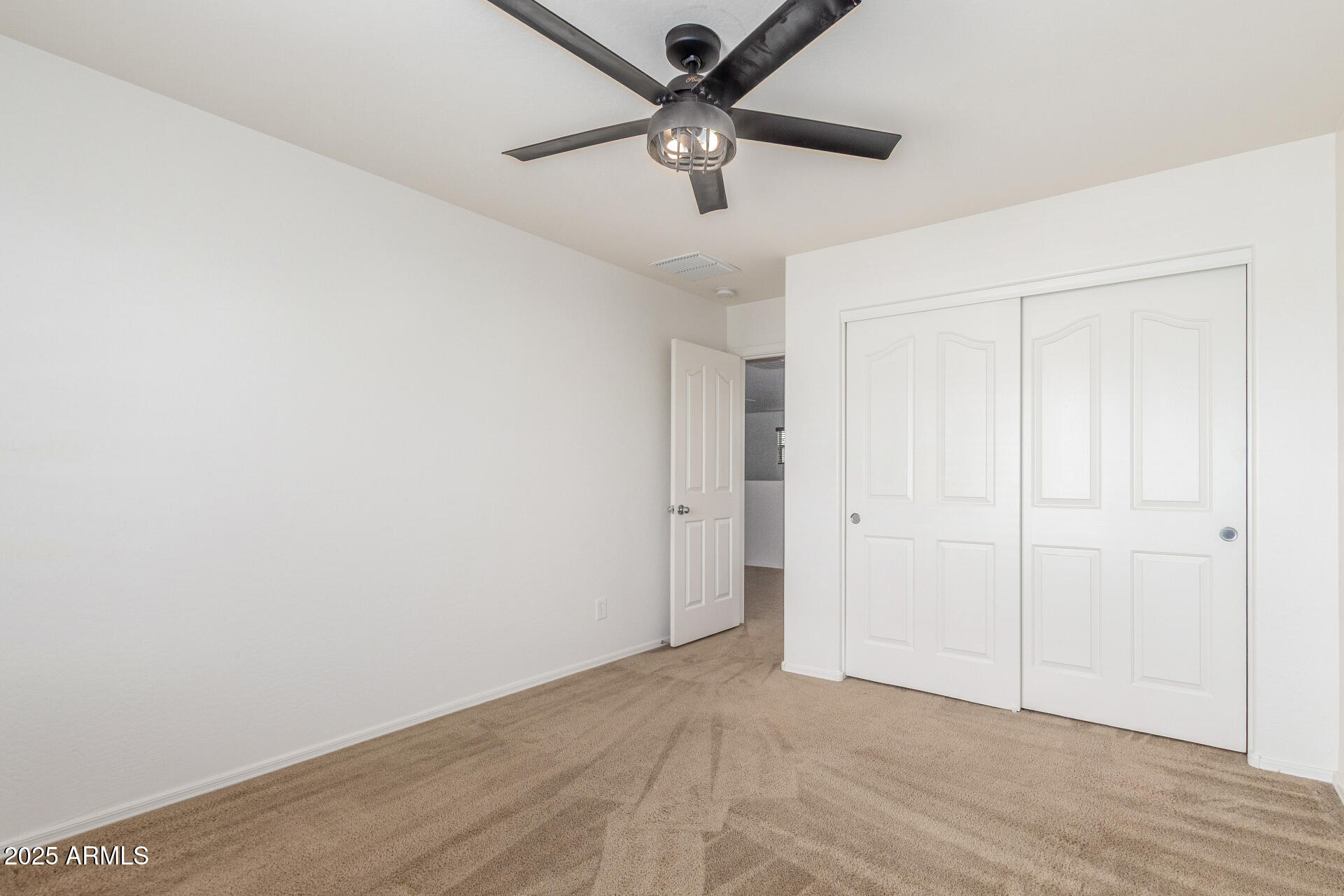 20932 Vía De Arboles Queen Creek, AZ 85142 - Photo 40 of 58 an empty room with a ceiling fan and carpet