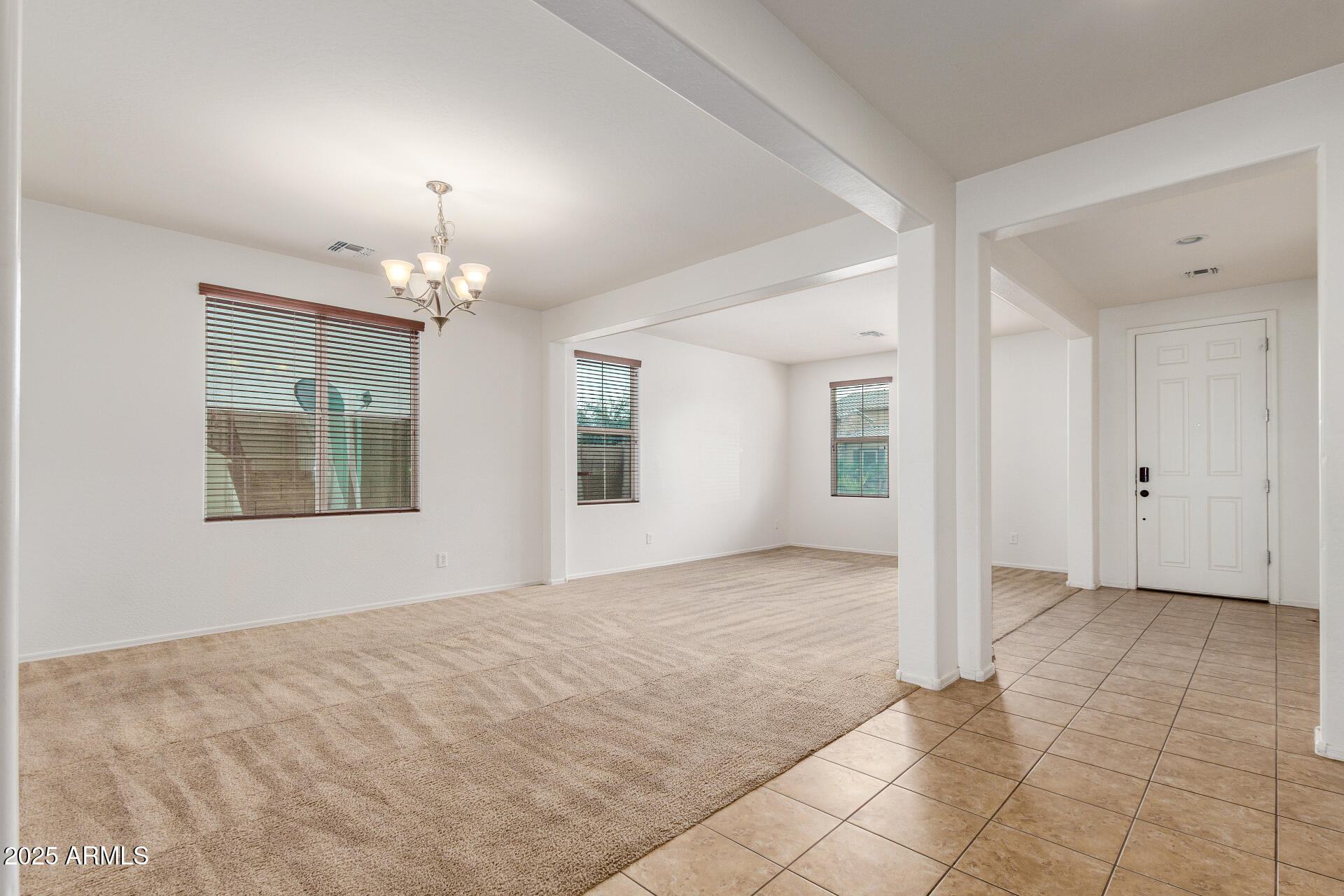 20932 Vía De Arboles Queen Creek, AZ 85142 - Photo 8 of 58 a view of an empty room with chandelier fan and kitchen view