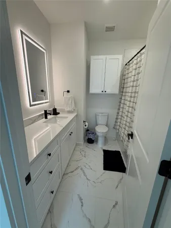 a bathroom with a sink toilet and shower