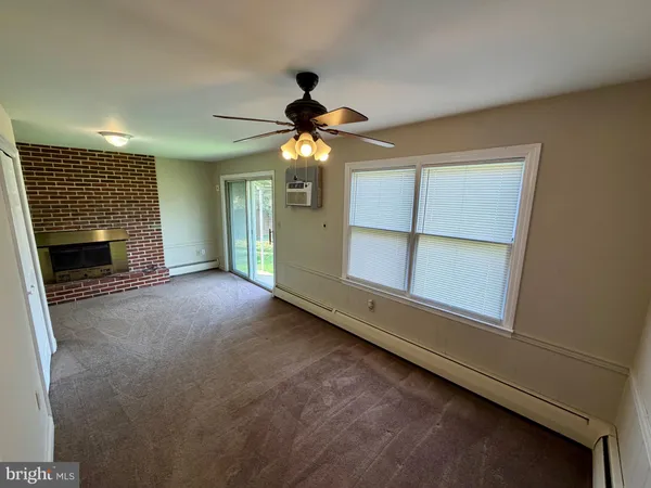 a view of a livingroom with an empty space and a fireplace