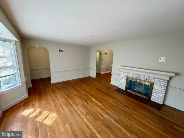 a view of empty room with wooden floor and fireplace
