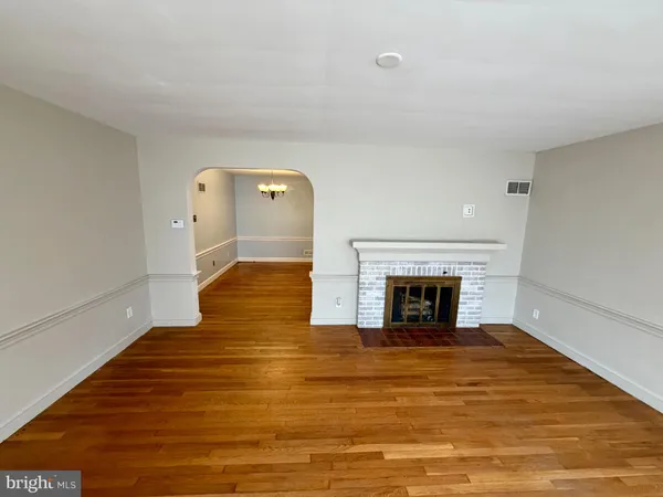 a view of a livingroom with wooden floor and a fireplace