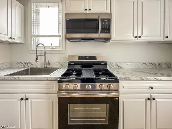 a stove top oven sitting inside of a kitchen
