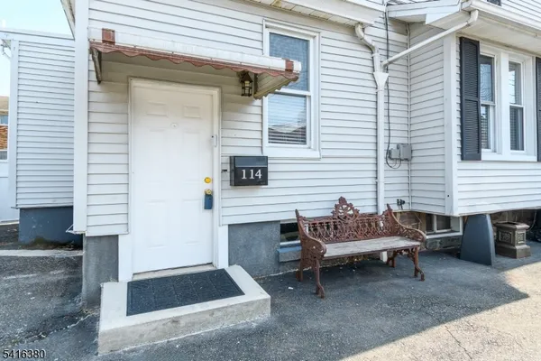 a backyard of a house with barbeque oven table and chairs