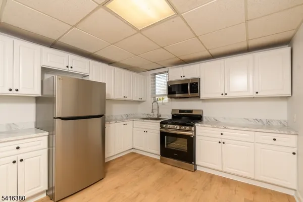 a kitchen with stainless steel appliances granite countertop a refrigerator stove a sink dishwasher and microwave with cabinets