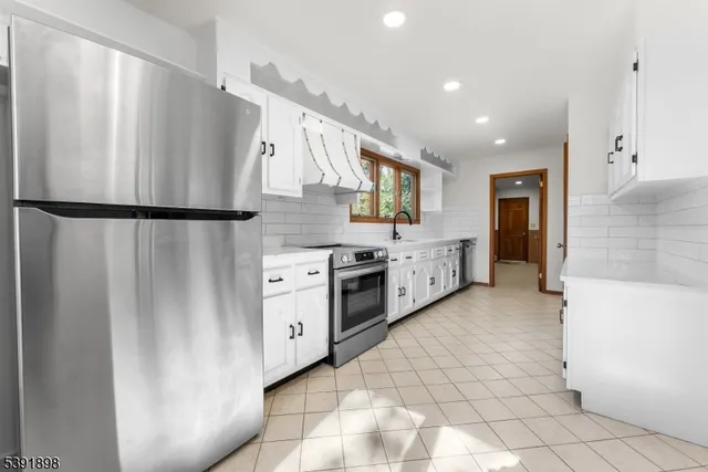a kitchen with stainless steel appliances a sink stove and cabinets