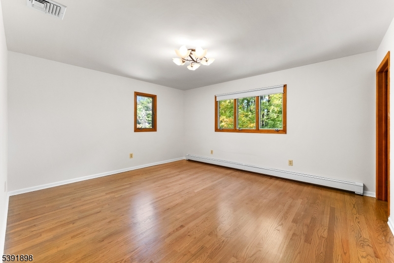 59 Cherryville Stanton Road Flemington, NJ 08822 - Photo 25 of 31 an empty room with wooden floor chandelier and windows