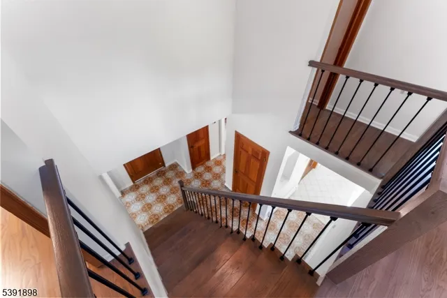a view of a hallway with wooden floor and stairs