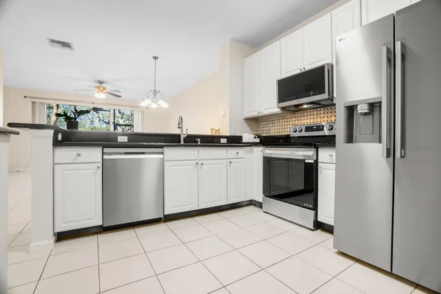a kitchen with white cabinets stainless steel appliances and sink