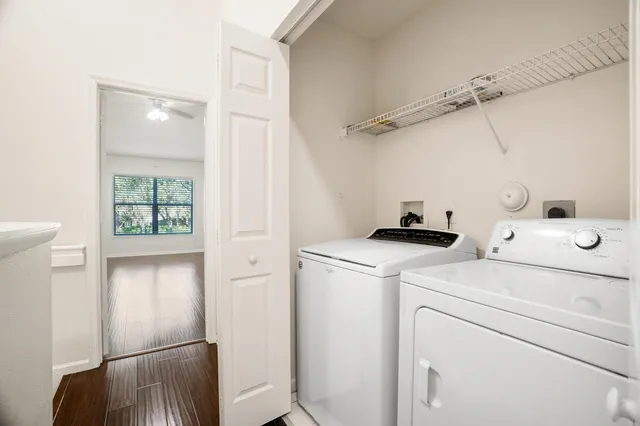 a view of washer and dryer with bathroom in the background