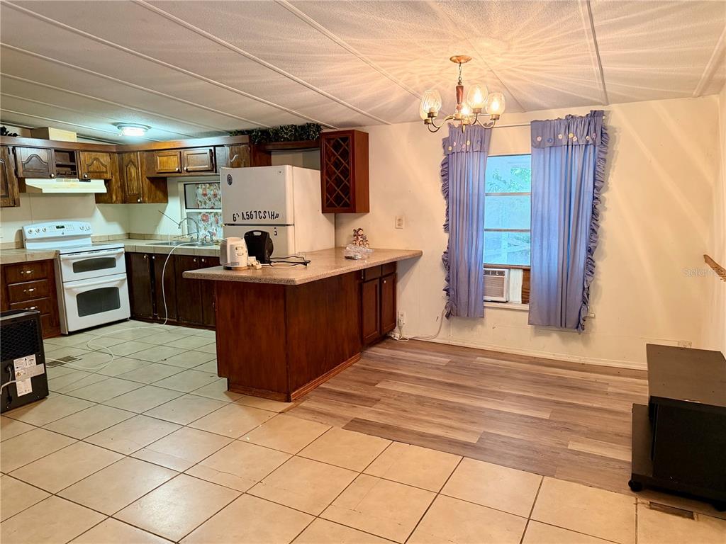 24021 Armadillo Road Astor, FL 32102 - Photo 12 of 38 a kitchen with stainless steel appliances kitchen island granite countertop a sink and cabinets
