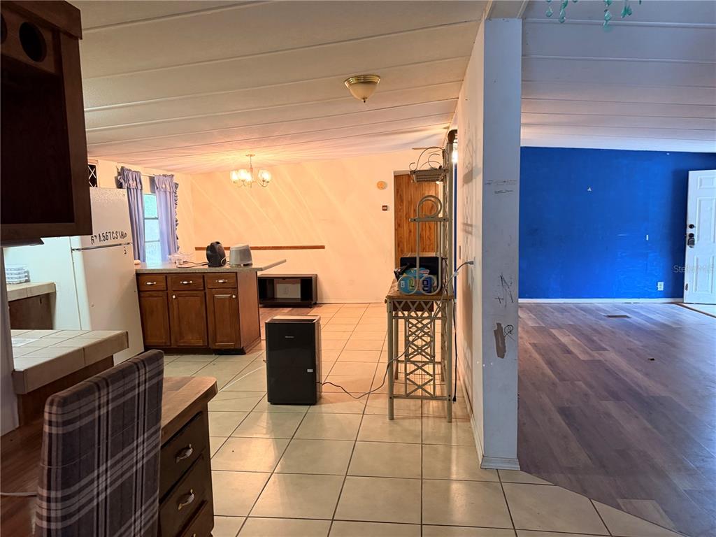 24021 Armadillo Road Astor, FL 32102 - Photo 13 of 38 a kitchen with a refrigerator and microwave