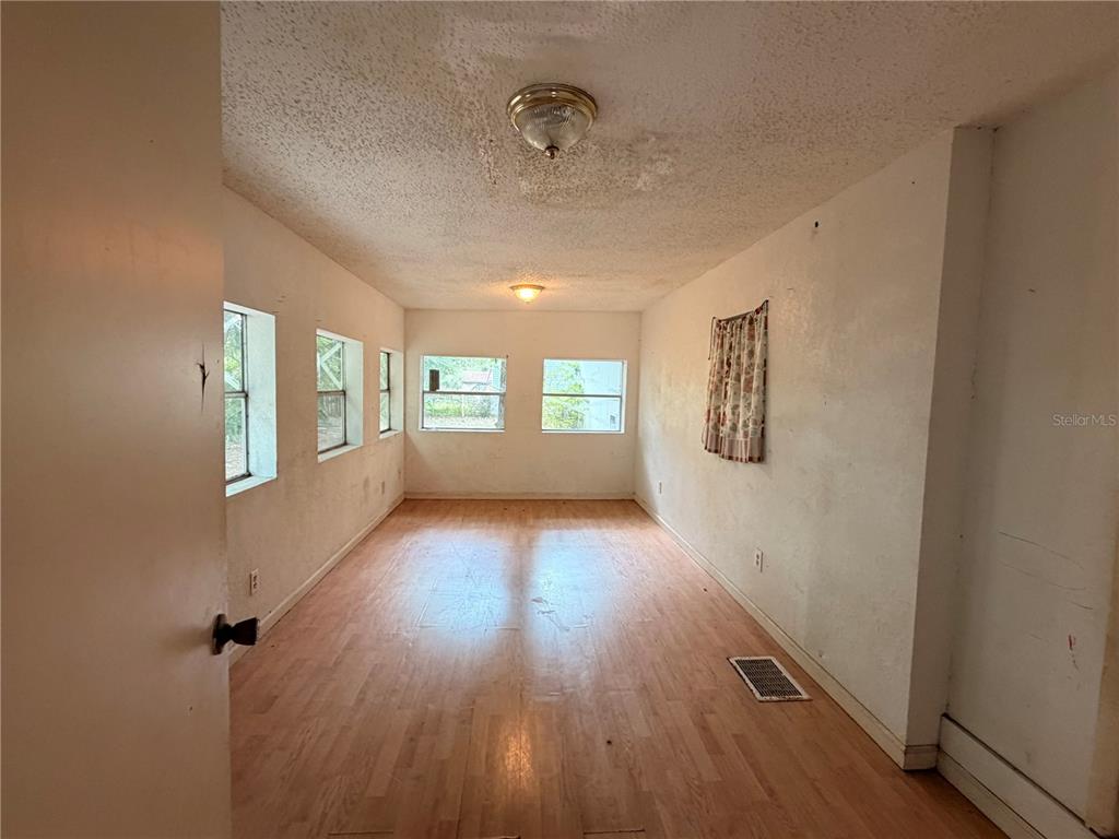 24021 Armadillo Road Astor, FL 32102 - Photo 25 of 38 wooden floor in an empty room with a window
