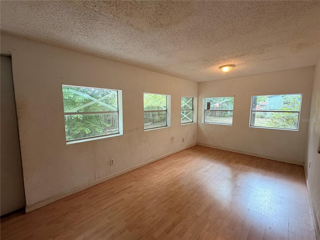 24021 Armadillo Road Astor, FL 32102 - Photo 26 of 38 an empty room with wooden floor and windows