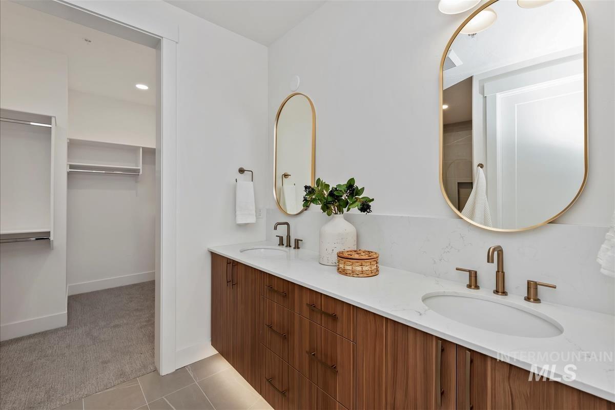 3243 West Moore Street Boise, ID 83702 - Photo 18 of 38 Bathroom with double vanity, light carpet, light tile patterned flooring, recessed lighting, and a walk in closet