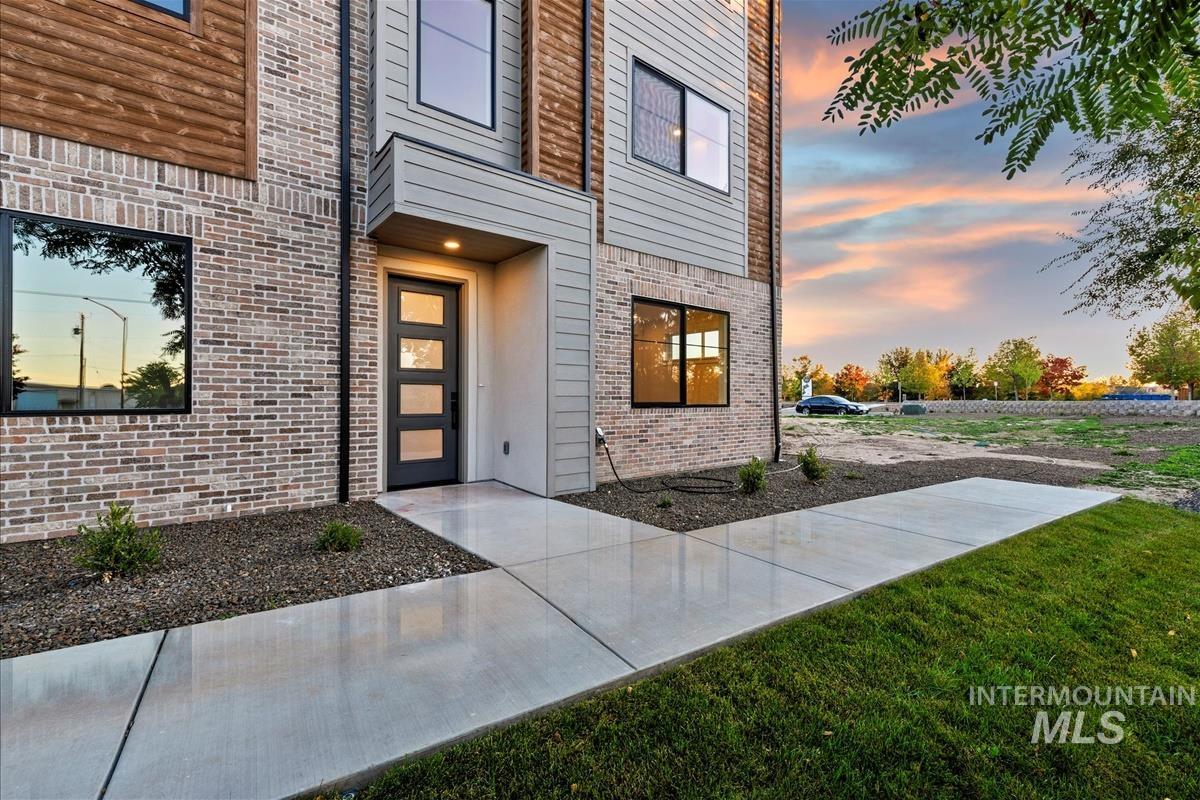 3243 West Moore Street Boise, ID 83702 - Photo 2 of 38 Exterior entry at dusk featuring brick siding and a yard