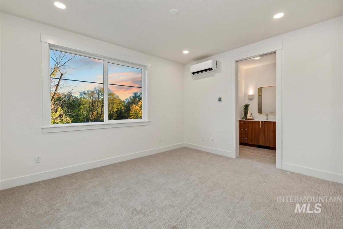 3243 West Moore Street Boise, ID 83702 - Photo 23 of 38 Unfurnished bedroom featuring light carpet, recessed lighting, ensuite bathroom, and a wall mounted air conditioner