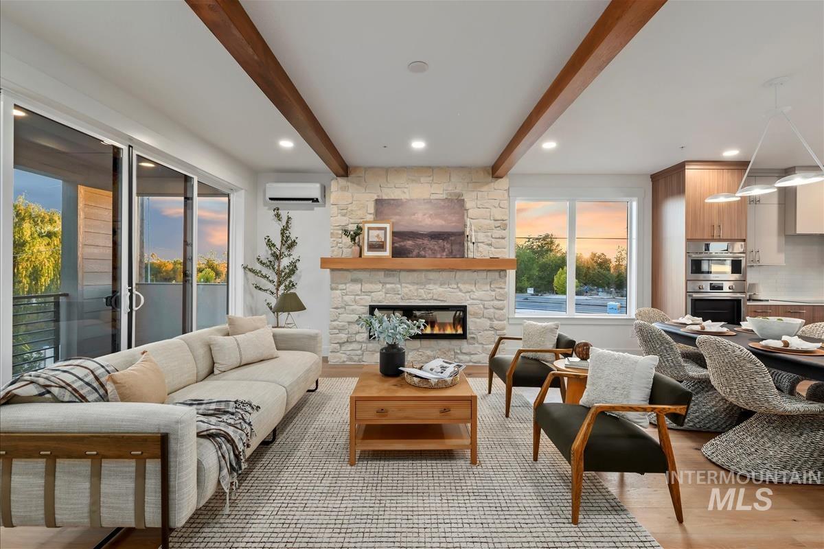 3243 West Moore Street Boise, ID 83702 - Photo 4 of 38 Living area with beamed ceiling, light wood-style flooring, a stone fireplace, a wall mounted air conditioner, and recessed lighting